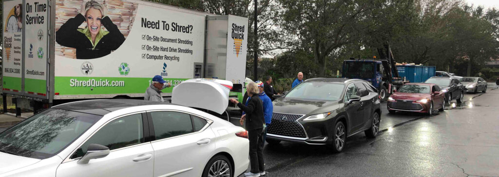 A line of cars next to a truck offering document shredding